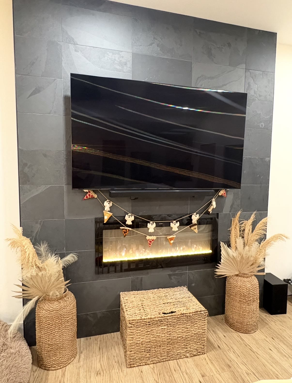 TV mounted over a slate tile electric fireplace