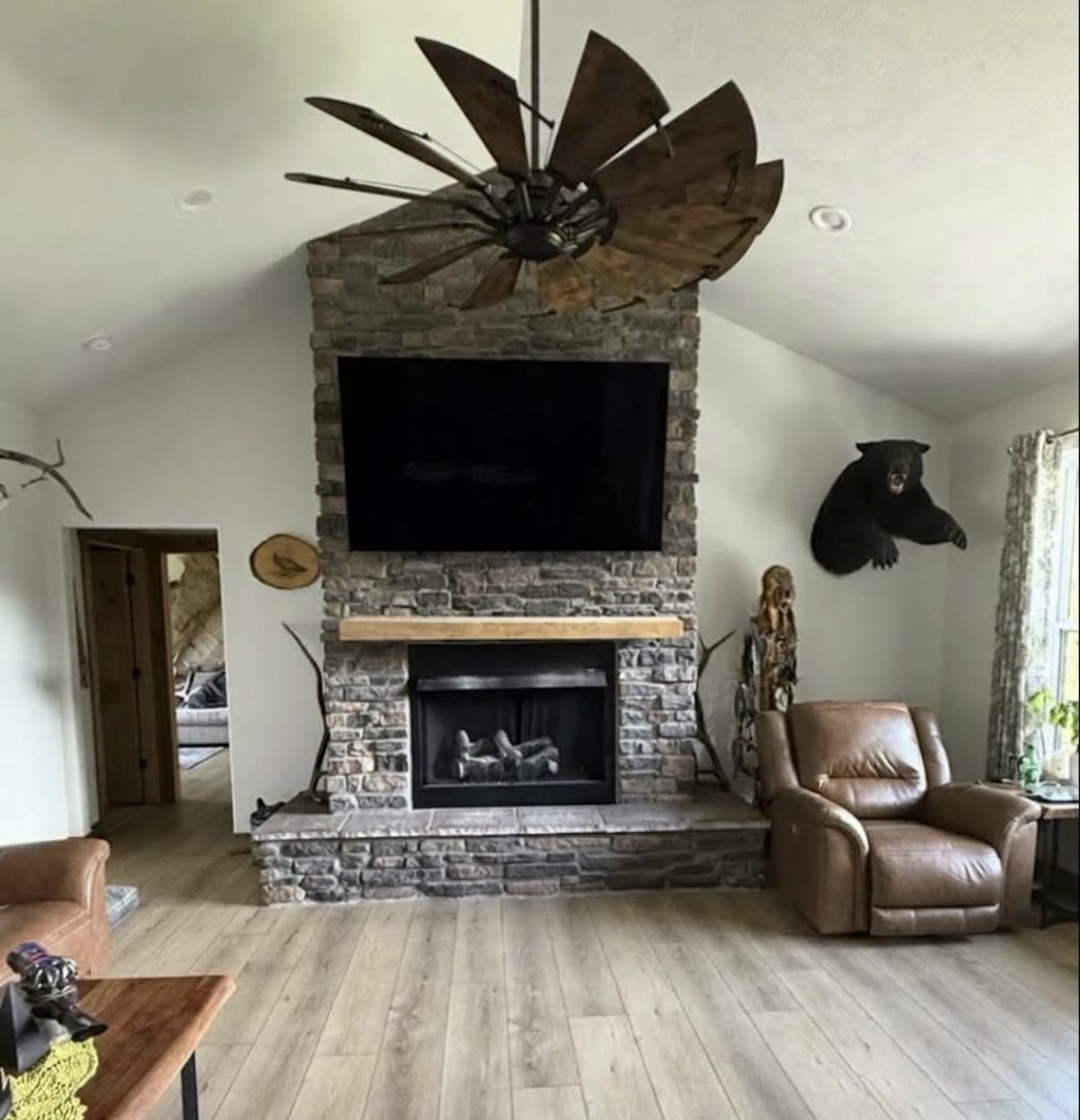 TV mounted over a dark tile fireplace in a bright living room