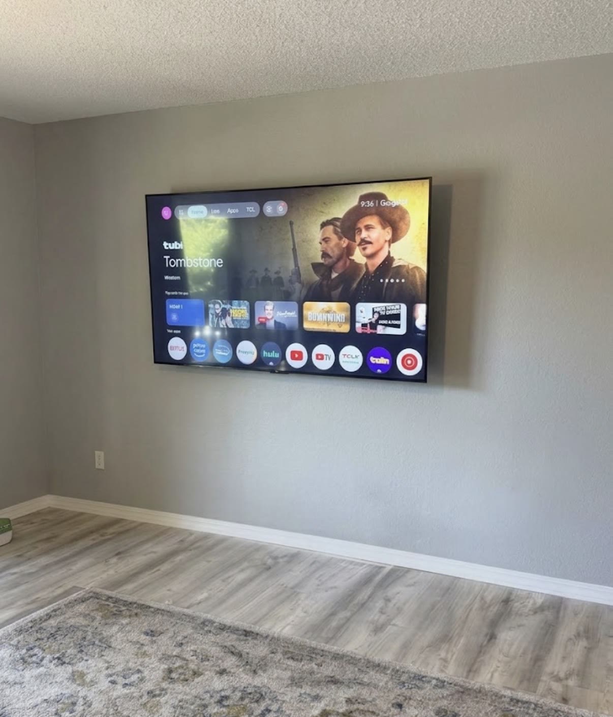 Large TV mounted on a clean gray drywall wall