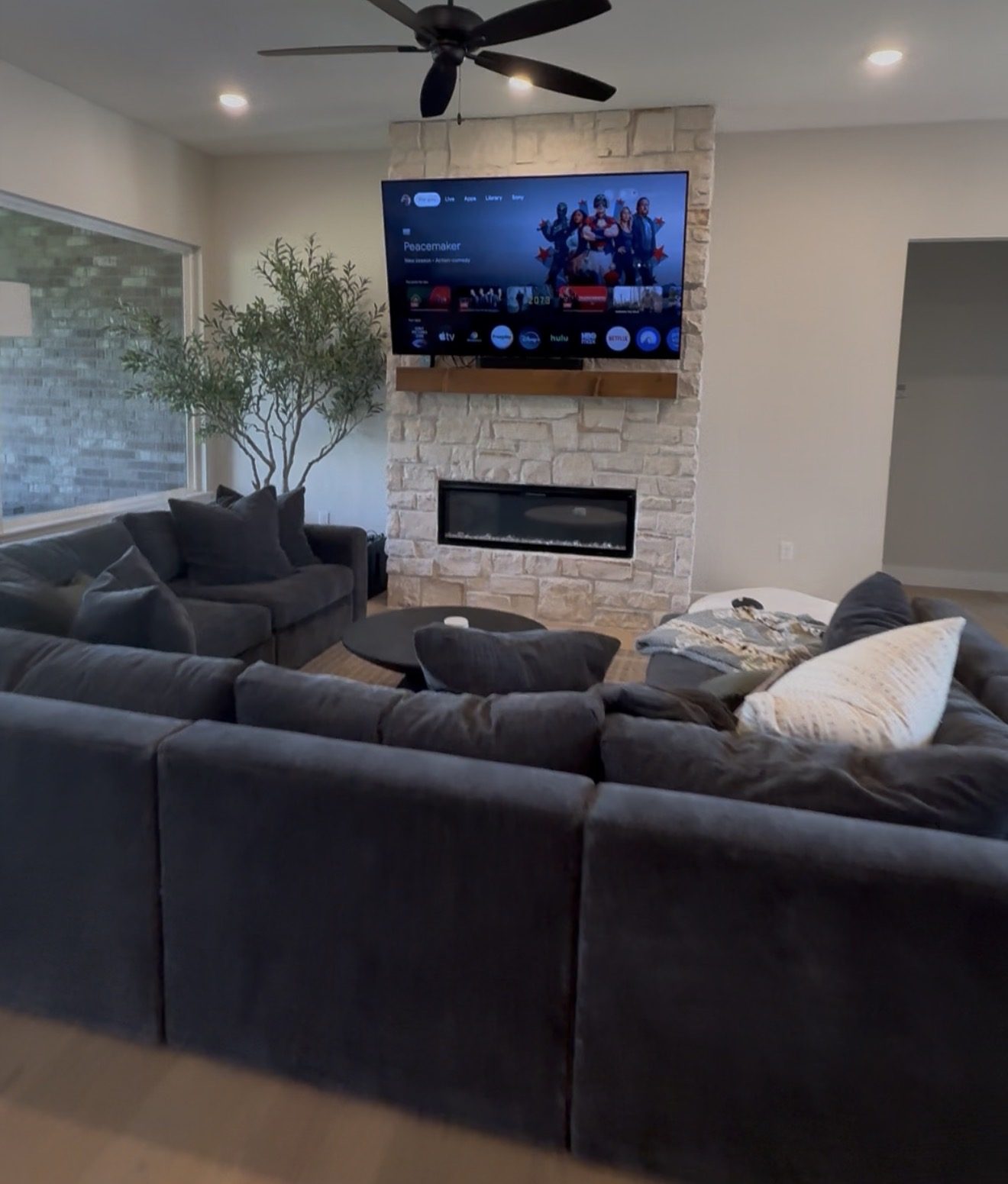 TV and soundbar mounted over a stacked stone fireplace
